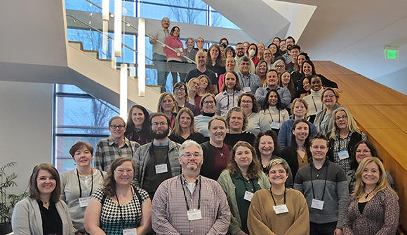 Open Educational Research State Action Teams from all MHEC member states, over 50 women and men standing on a stairwell.